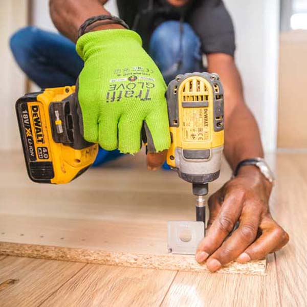 man holding drill installing wood piece
